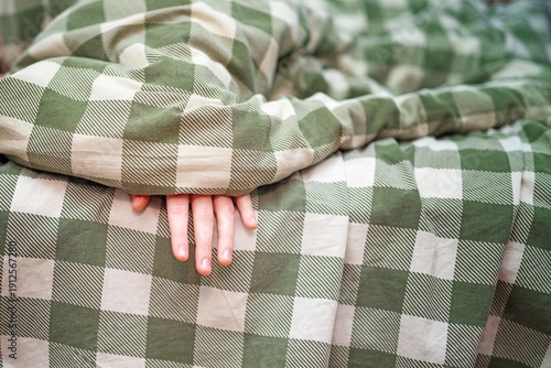 Wallpaper Mural Teenager's fingers slightly peeking out from under a warm green plaid wool blanket. Cozy rest and comfort concept. Torontodigital.ca