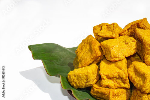 A close up commercial three-quarter angle shot of savory fried tofu, showing both the top and side textures of the food.