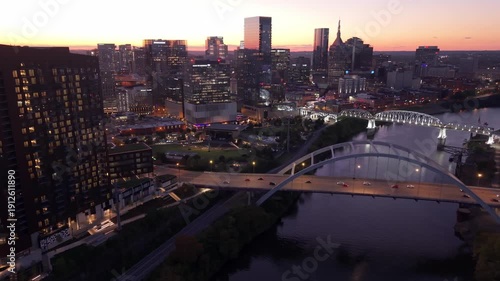 Wallpaper Mural Downtown Nashville, sunset lights over the Cumberland River, approaching traffic on bridge, aerial evening forward shot Torontodigital.ca