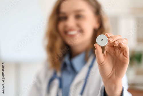 Female doctor with glucose sensor in office, closeup
