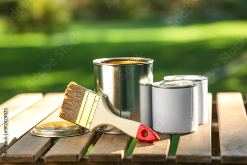 Paint can with brush on woo...