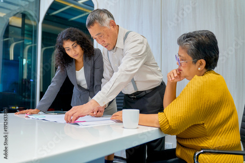 Diverse business team working in meeting room with papers to plan business marketing.