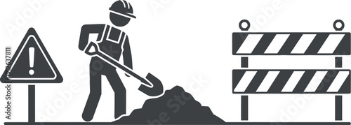 Construction worker digging with safety signs and barriers