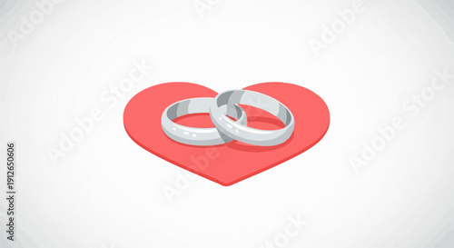Two simple silver rings rest on a red heart shape against a white backdrop