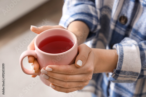 Young woman holding cup of ...