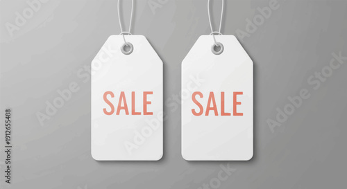 Two white price tags with the word "SALE" printed in coral on a gray background