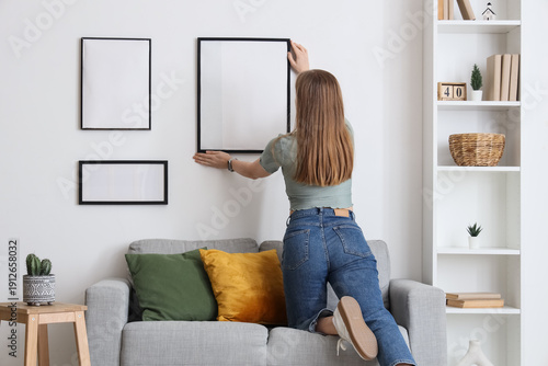 Woman hanging blank photo f...