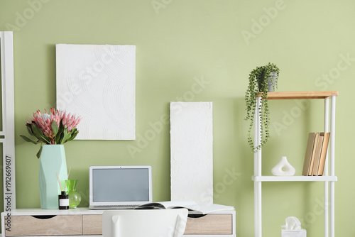 Blank laptop and vase with ...