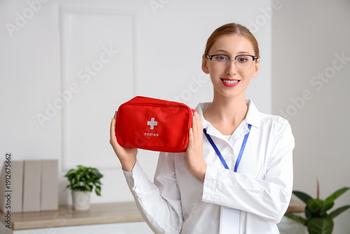 Happy female doctor with ba...