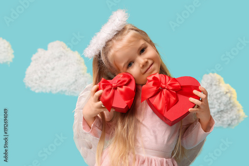 Cute little girl dressed as cupid with gift boxes and clouds on blue background. Valentine's Day celebration