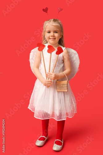Cute little girl dressed as cupid with arrows on red background. Valentine's Day celebration