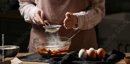 Woman adding flour for prep...