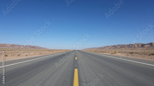 Endless Highway Through Arid Landscape Underneath Clear Blue Sky, Depicting a Sense of Freedom and Journey