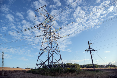 Electricity pylons in a field with blue sky