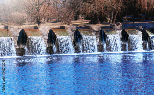 Purified water flows into river. Water treatment plant releases clean water. Public water supply system works well. Safe drinking water resource