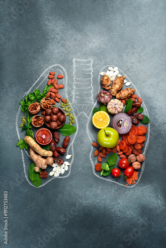 The best foods for healthy lungs and breathing. Assortment of natural products to boost lungs health and lungs drawing on a gray textured background. Healthy diet for lungs.