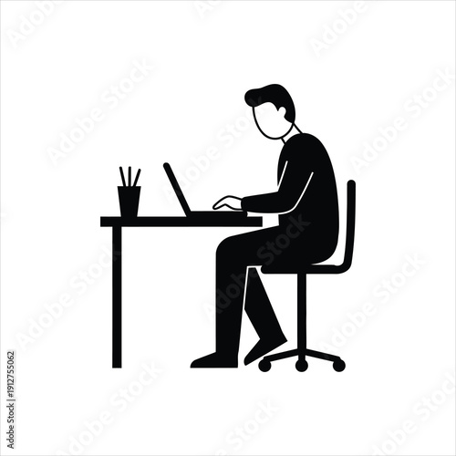 A silhouette of a person sitting at a desk and working on a laptop computer