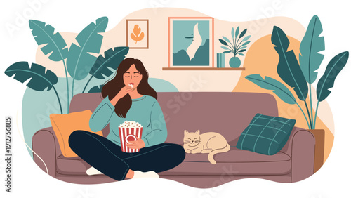 Relaxed woman sitting on a comfortable sofa and eating popcorn while watching a movie at home with her cat lying beside her.
