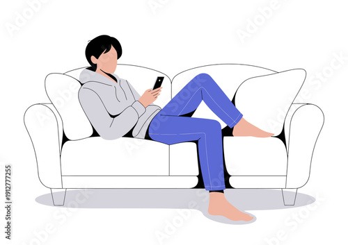 A young man wearing a hoodie is comfortably lounging on a couch while using his smartphone, showcasing relaxation and modern lifestyle in contemporary interior design.