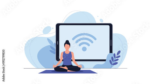 Young woman practicing yoga in a lotus pose on a mat in front of a large tablet showing a wifi signal for online wellness.