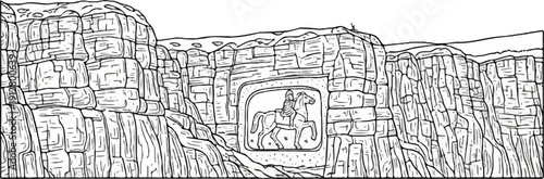 A stone carving of a person on horseback embedded in a rocky cliff face