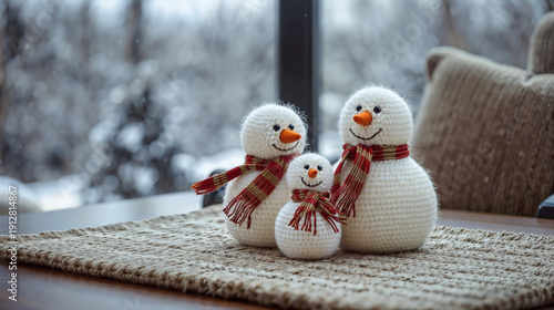 Charming Three Crochet Snowmen Family with Festive Scarves on White Rug and Window Bokeh - Trendy Handmade Holiday Craft Image for Blogs and Printables.