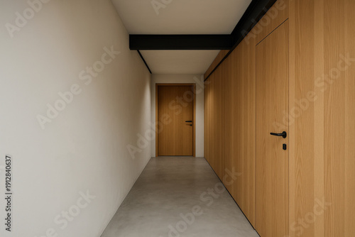Long hallway with wooden furniture and a door at the end in a simple indoor space during daytime
