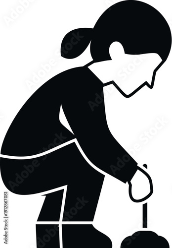 Woman in silhouette crouching, holding a fishing rod over an ice hole