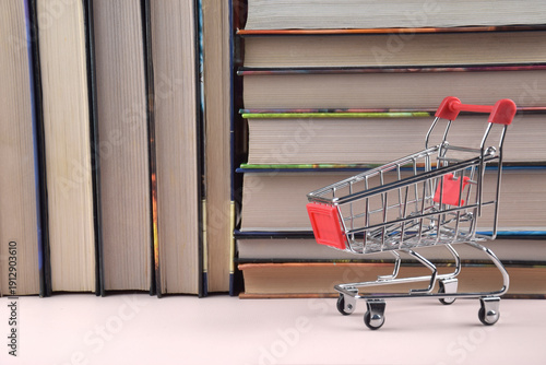 A shopping cart with many books in the background.