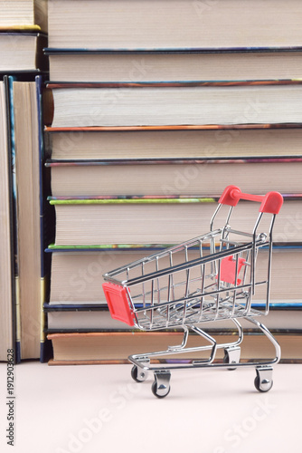 A shopping cart with many books in the background.