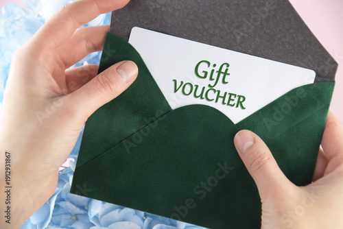 Gift voucher in a green envelope on a light background