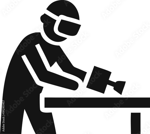 Focused professional wearing safety gear operates a power tool on a workpiece at a sturdy workbench