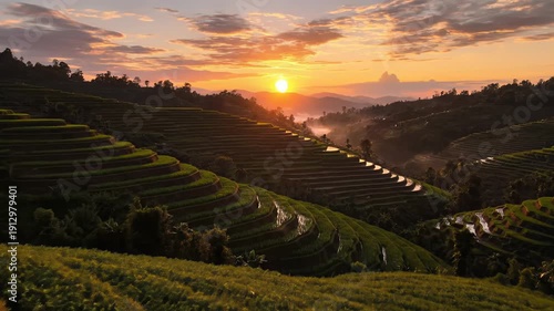 Golden Sunrise Over Lush Green Rice Terraces in a Misty Valley with Dramatic Clouds
