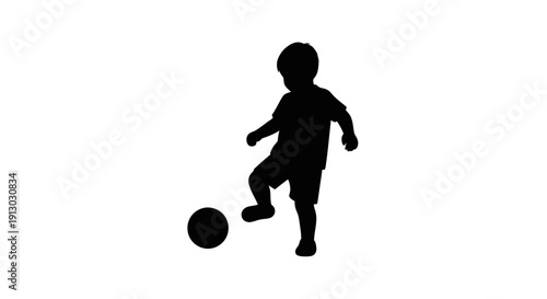 Silhouette of a boy playing soccer.