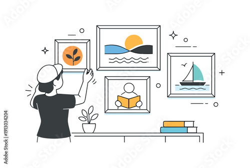 Arranging framed art prints. A calm interior wall with a few framed art prints being carefully aligned, clean and balanced. The scene