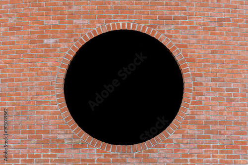 Dettaglio di un muro di mattoni con al centro un buco nero