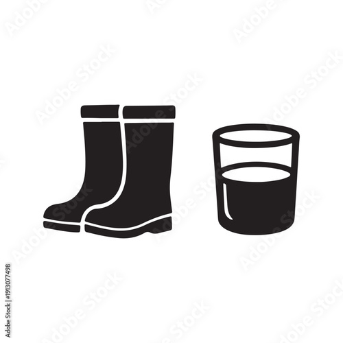 A pair of black rubber boots and a glass of milk on white background