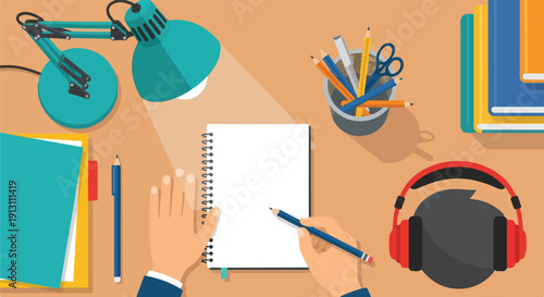 Top view of hands writing in a notebook on a desk with a lamp, headphones, and books, symbolizing education and creativity.