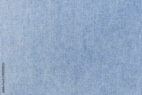 Light denim fabric closeup showing indigo weave and fine threads, subtle faded wash, cotton texture for heritage denim styling, product background or textile mockup for sustainable fashion campaigns