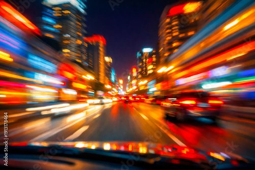 Modern city motion blur. Abstract cityscape with traffic at night. Moving through modern city street with illuminated skyscrapers seen through a car window. 
