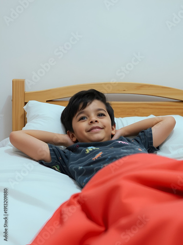Boy (4-5) lying in bed