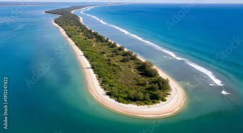 Aerial view of a serene, narrow island with lush greenery and pristine sandy beaches.