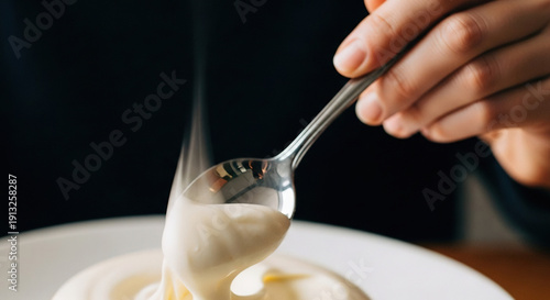 Hand Stirring Creamy Sauce in White Bowl