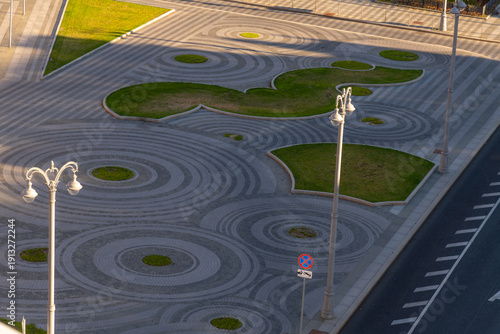 Circles and shapes on pavement in city park during late afternoon