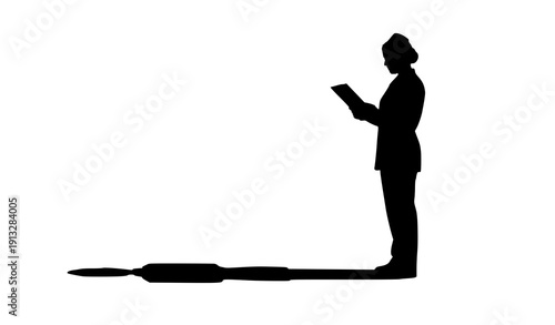 Silhouette Reflection: A solitary figure, absorbed in reading on a digital device, casts a long shadow on the ground, suggesting introspection and intellectual pursuit. 