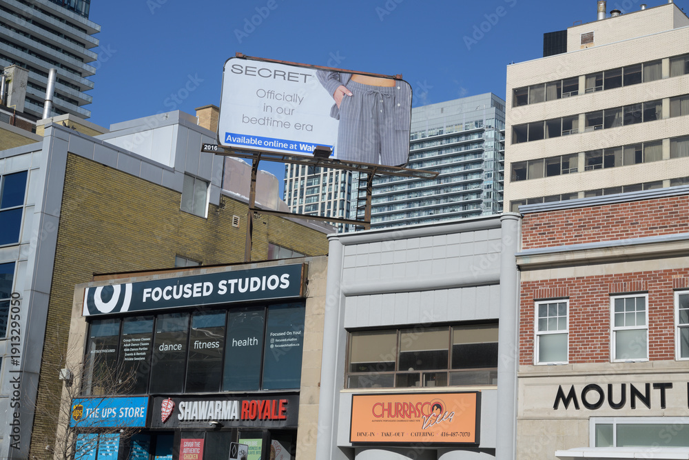 Fototapeta premium rooftop billboard and businesses, north side, Eglinton Av E at Mount Pleasant Station, Eglinton Line, Line 5, Toronto