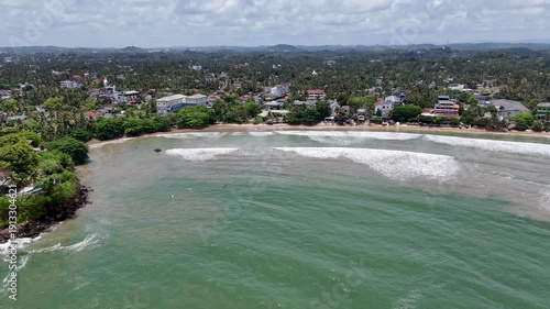 Galle, Sri Lanka, November 3, 2025: Devata Beach in the galle city and surfers riding in the waves