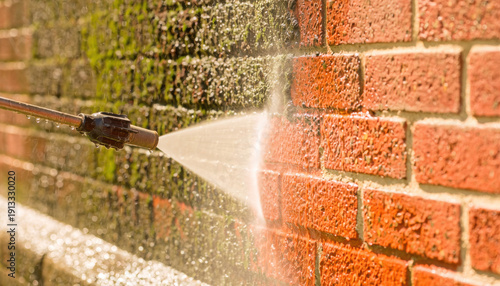 Power washing brick wall removing moss and dirt