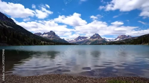 Time-lapse style: Clouds moving rapidly over a clean, mountain lake.
