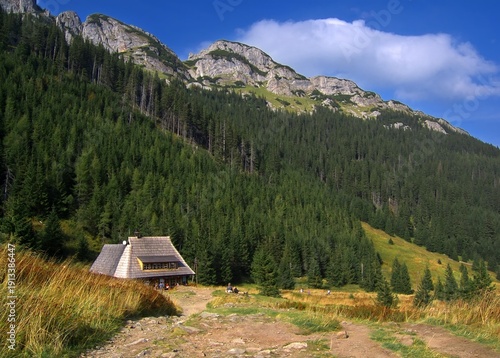 Mountain shelter in the Tatra Mountains. Rocky peaks and green slopes create a majestic backdrop for the traditional architecture.
